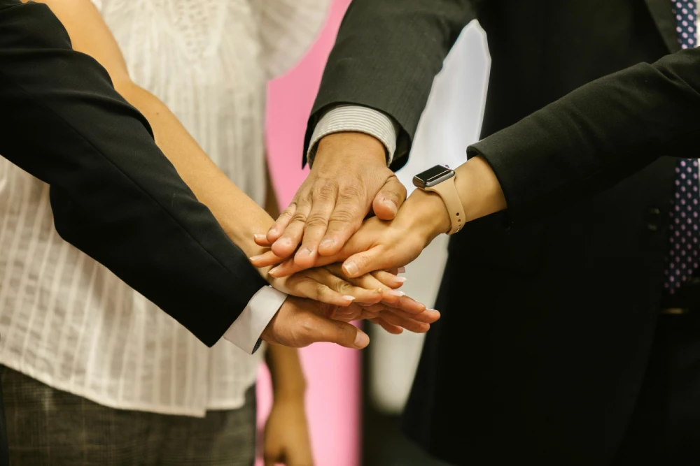 a group of people putting their hands together